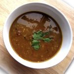 A bowl of Sambhar (Spiced Lentil Soup) garnished with fresh cilantro leaves