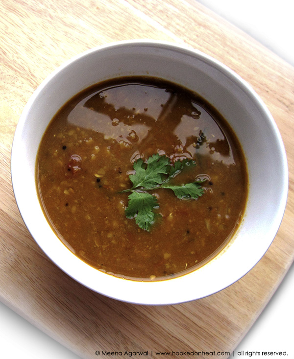 A bowl of Sambhar (Spiced Lentil Soup) garnished with fresh cilantro leaves