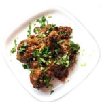 A plate of Masala Chicken Palak (Sauteed Chicken with Spinach) garnished with fresh cilantro.