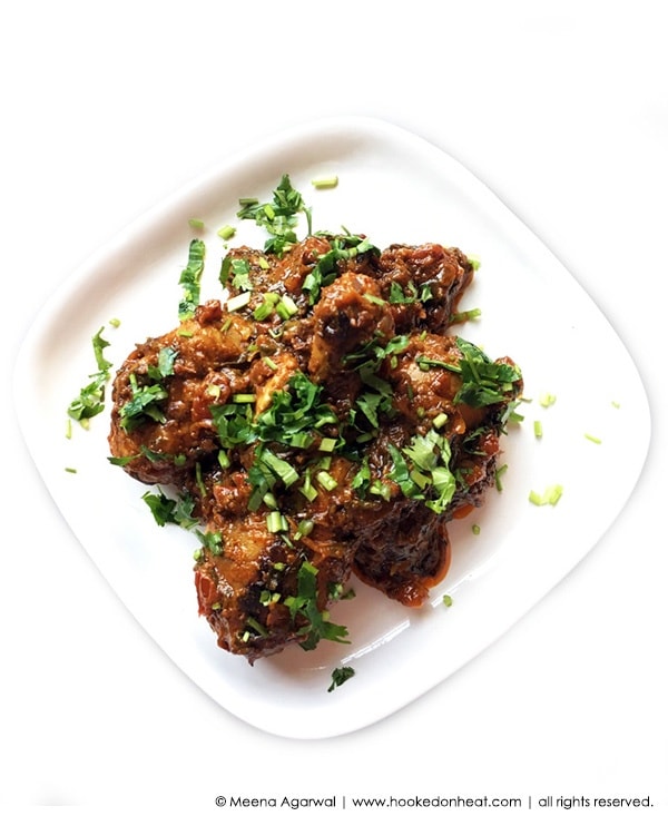 A plate of Masala Chicken Palak (Sauteed Chicken with Spinach) garnished with fresh cilantro.