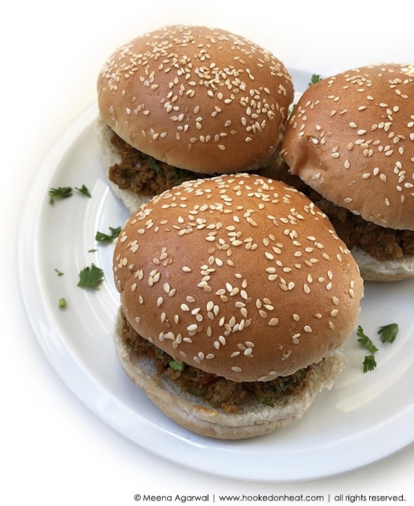 A plate of three Bun Keema sandwiches garnished with fresh cilantro