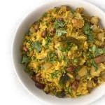 A bowl of Matar Poha garnished with fresh cilantro