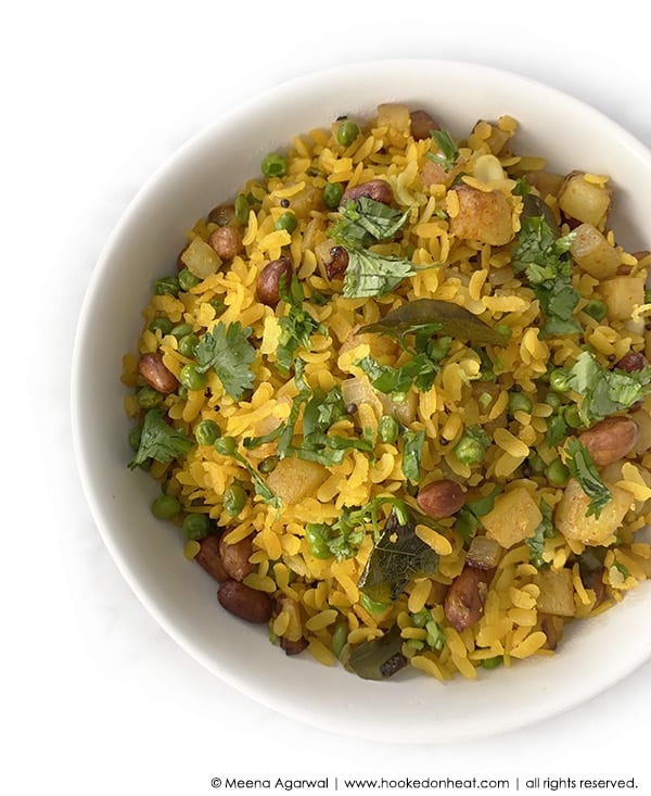 A bowl of Matar Poha garnished with fresh cilantro