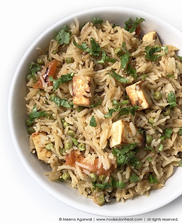 A bowl of Paneer Pulao garnished with fresh cilantro.