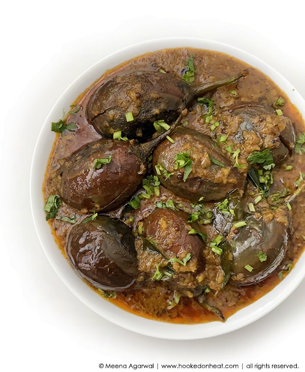 A bowl of Baingan Masala or Aubergine Curry garnished with fresh cilantro.