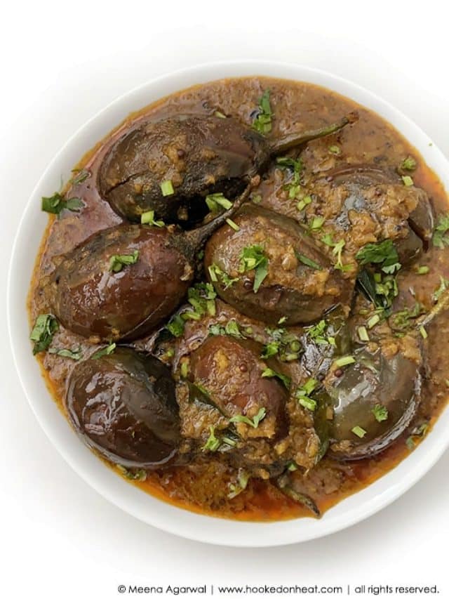 A bowl of Baingan Masala or Aubergine Curry garnished with fresh cilantro.