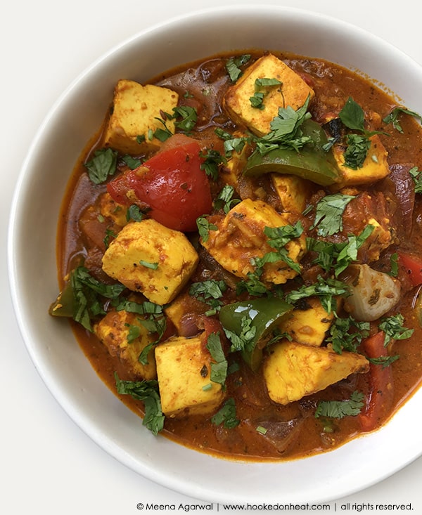 A bowl of Paneer Jalfrazie (Stir-fried Paneer in mild Tomato Sauce) garnished with fresh cilantro.