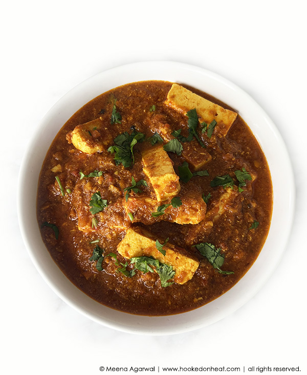 A white bowl of Dahiwali Paneer which is a low-fat version of the classic Paneer Makhani, garnished with finely chopped fresh cilantro.